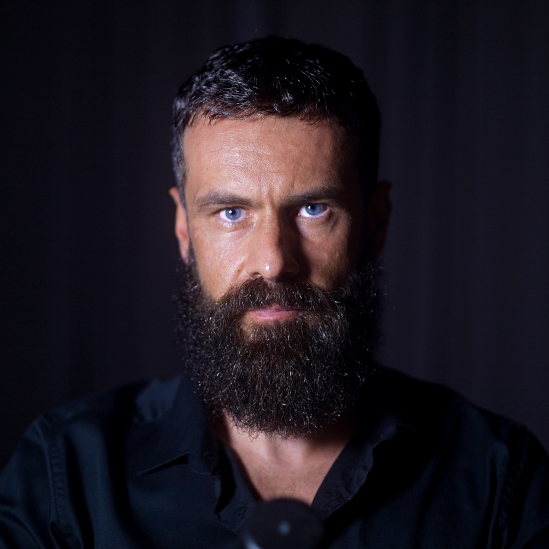 "Védský průvodce – muž s intenzivním pohledem ve hře světla a stínů symbolizuje hloubku sebepoznání, duchovní vedení a hledání rovnováhy skrze védské tradice, jógu a ájurvédu.